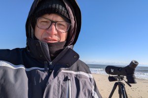 Me. On the beach with a birding scope. Being cold.